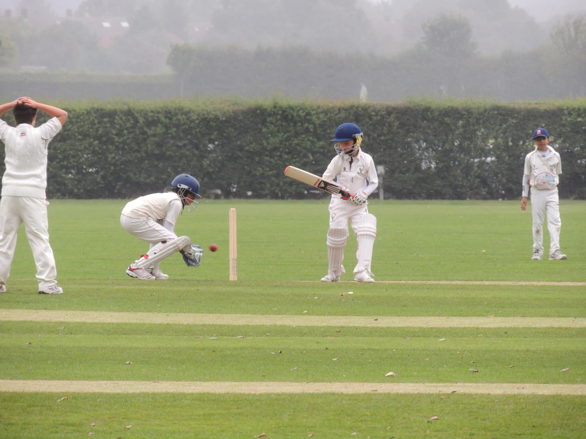 Cricket game young players in white