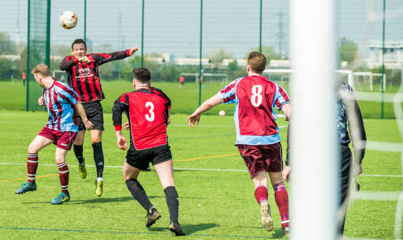 Football game seen through the goal posts - pitch hire